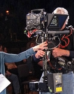 The floor director is counting down to “Action!” for a take with the steadicam prompter.