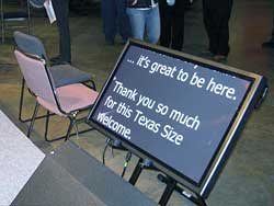 This downstage monitor is too close to the stage, and makes the presenter look down and away from the audience.